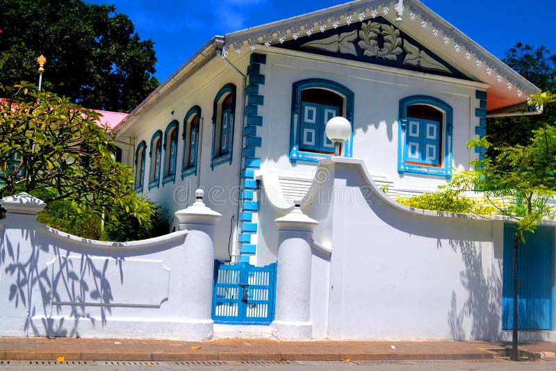 Traditional Maldivian building with white-blue colour scheme, ornate gables, and floral carvings